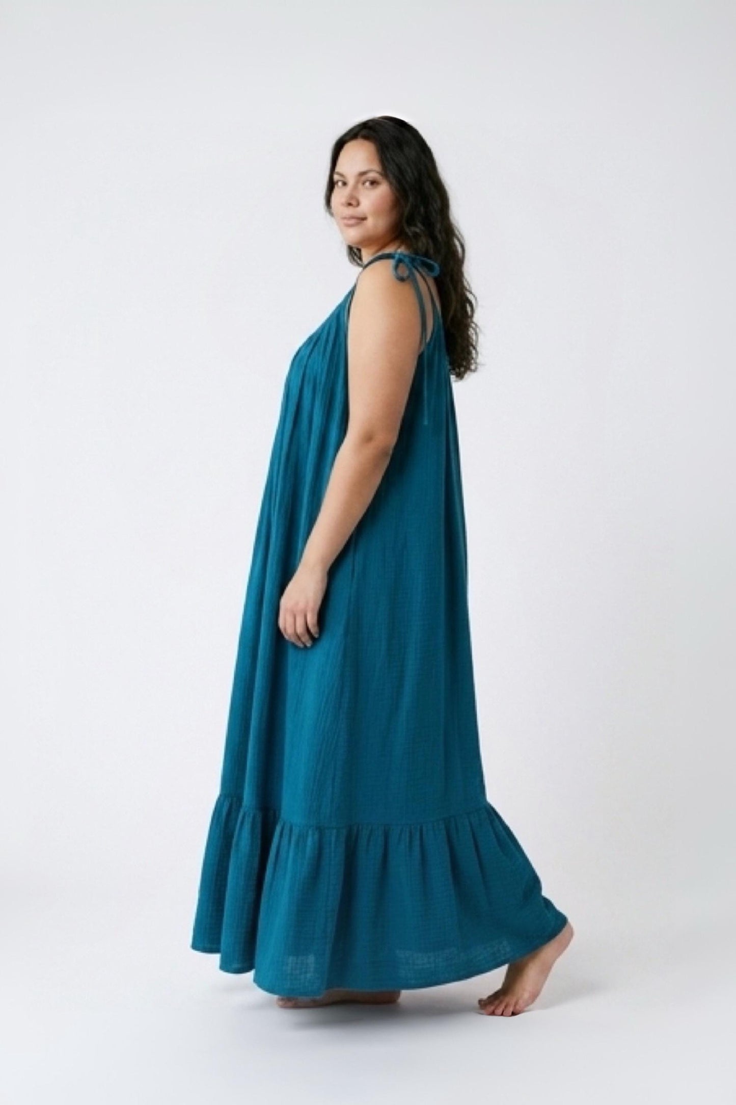 Blue turquoise open back maxi dress with tie shoulders and a flowy oversized fit on the beach.