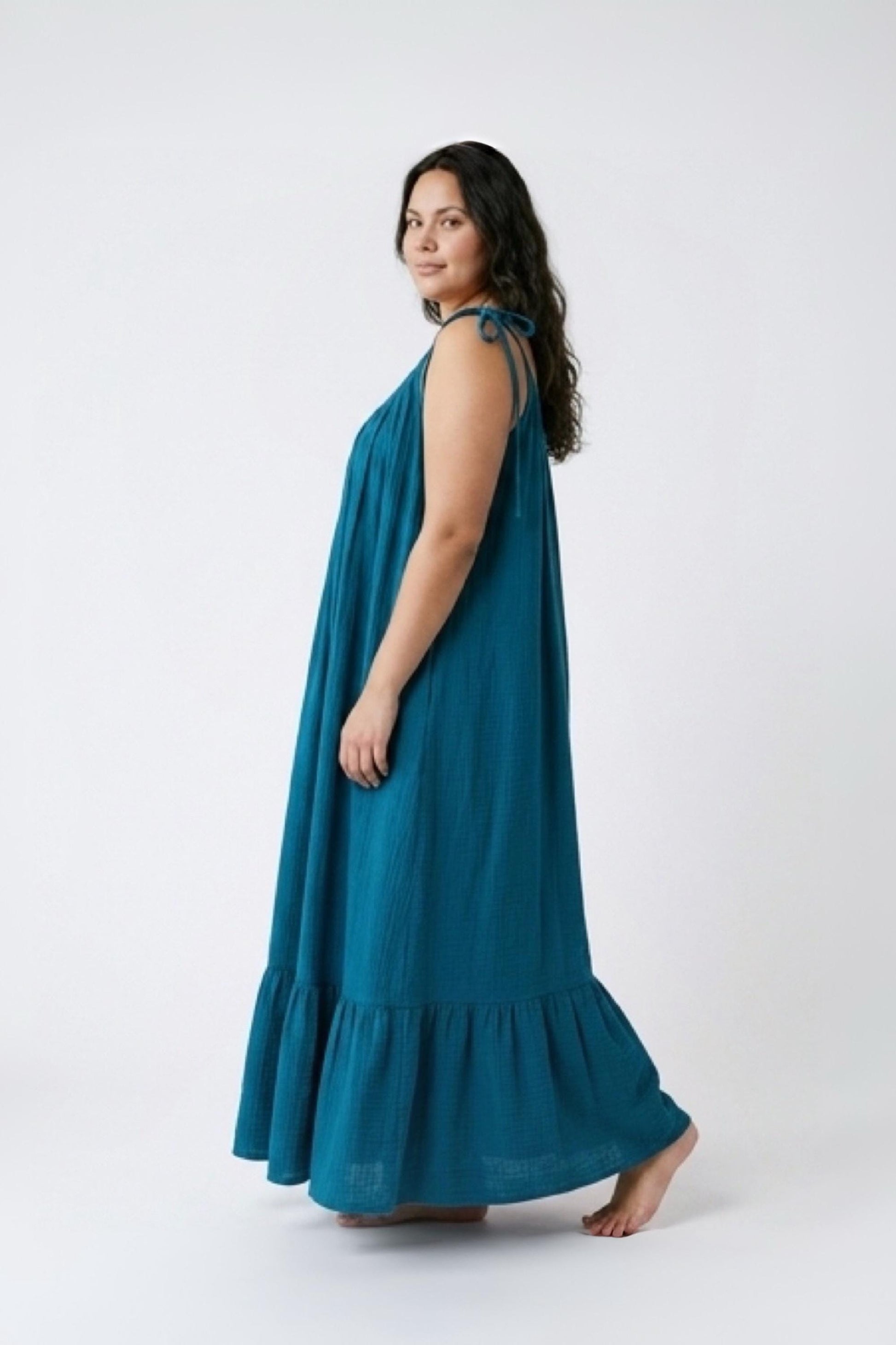 Blue turquoise open back maxi dress with tie shoulders and a flowy oversized fit on the beach.
